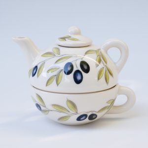 White ceramic teapot and cup set with a pattern of black olives and green leaves